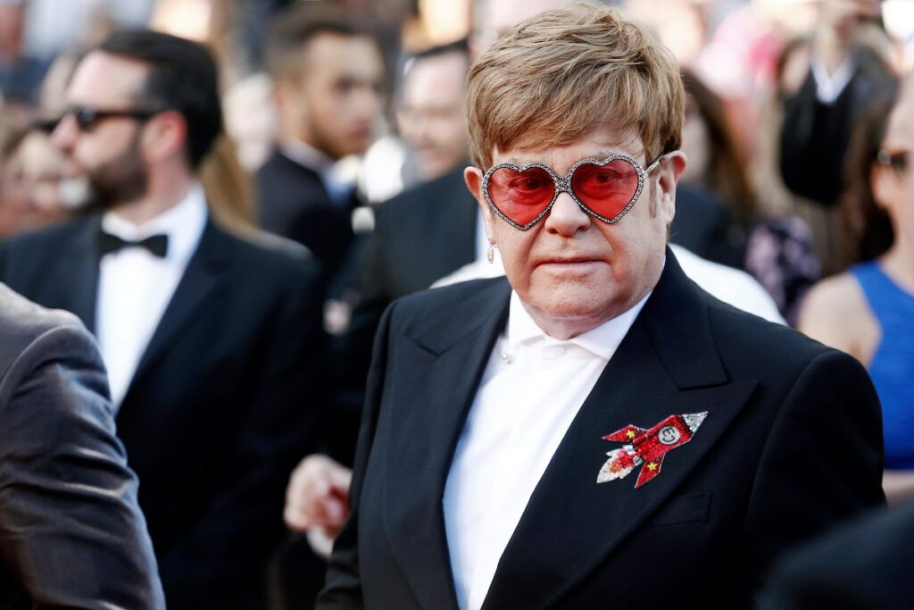 Elton John in Anzug und Brille